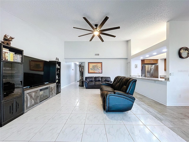 living room with ceiling fan and a textured ceiling