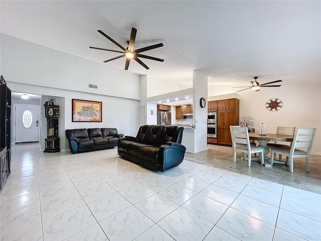 living room featuring a textured ceiling, high vaulted ceiling, and ceiling fan