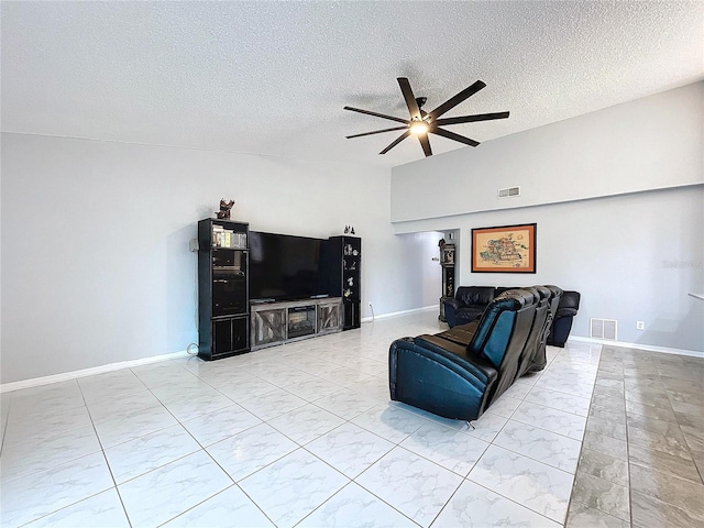 living room with ceiling fan and a textured ceiling