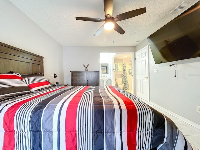 bedroom with ensuite bath, ceiling fan, and a textured ceiling