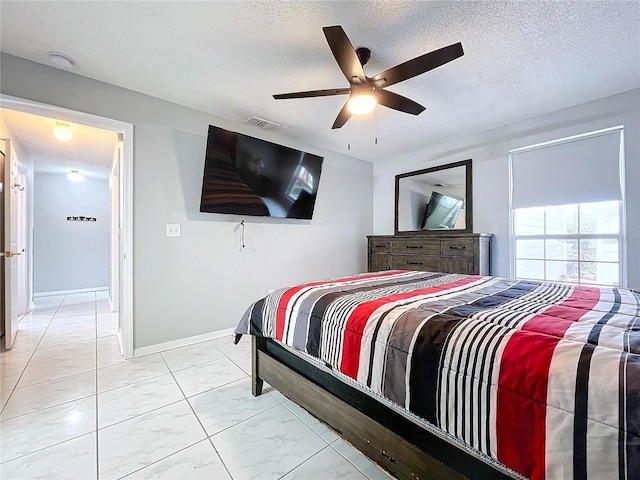 bedroom with a textured ceiling and ceiling fan