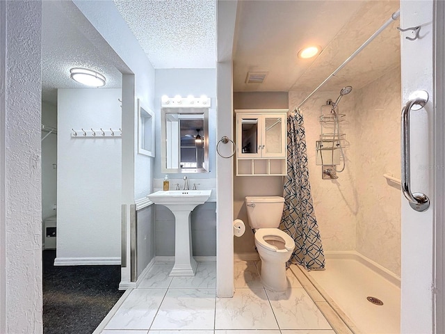 bathroom featuring toilet, a textured ceiling, and walk in shower