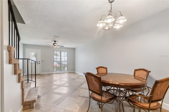 dining space featuring a textured ceiling and ceiling fan with notable chandelier