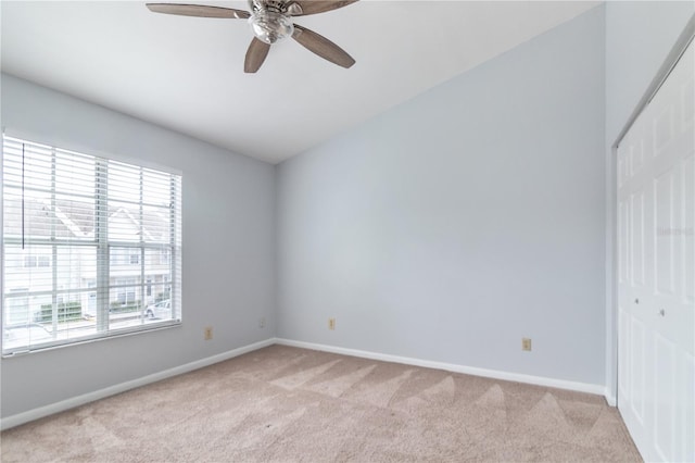 carpeted spare room featuring ceiling fan and plenty of natural light