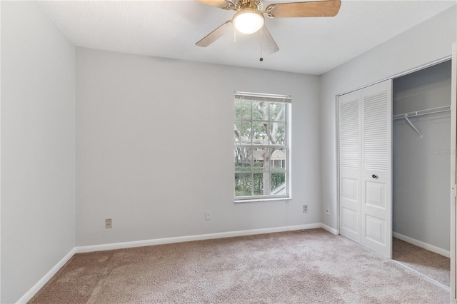 unfurnished bedroom featuring ceiling fan, a closet, and light carpet