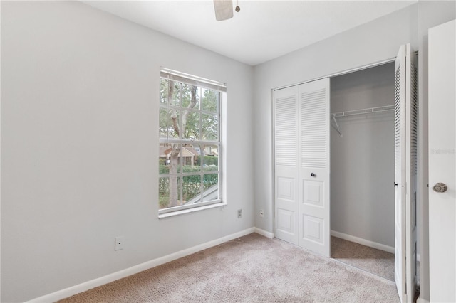 unfurnished bedroom with ceiling fan, a closet, and light carpet