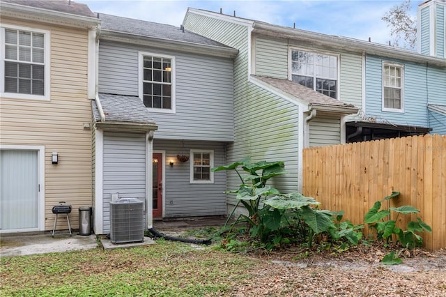 rear view of house featuring central AC