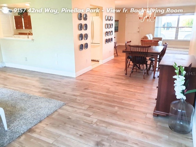 dining room with hardwood / wood-style flooring and a notable chandelier