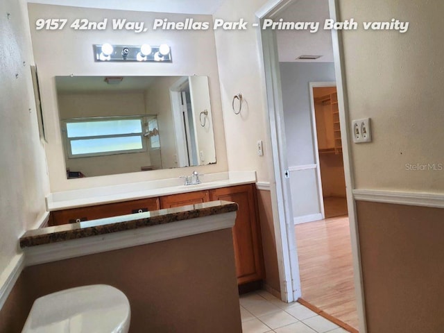 bathroom with tile patterned flooring, vanity, and toilet