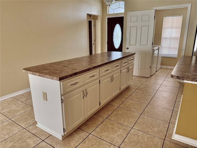 kitchen featuring white cabinets, a kitchen island, and light tile patterned floors