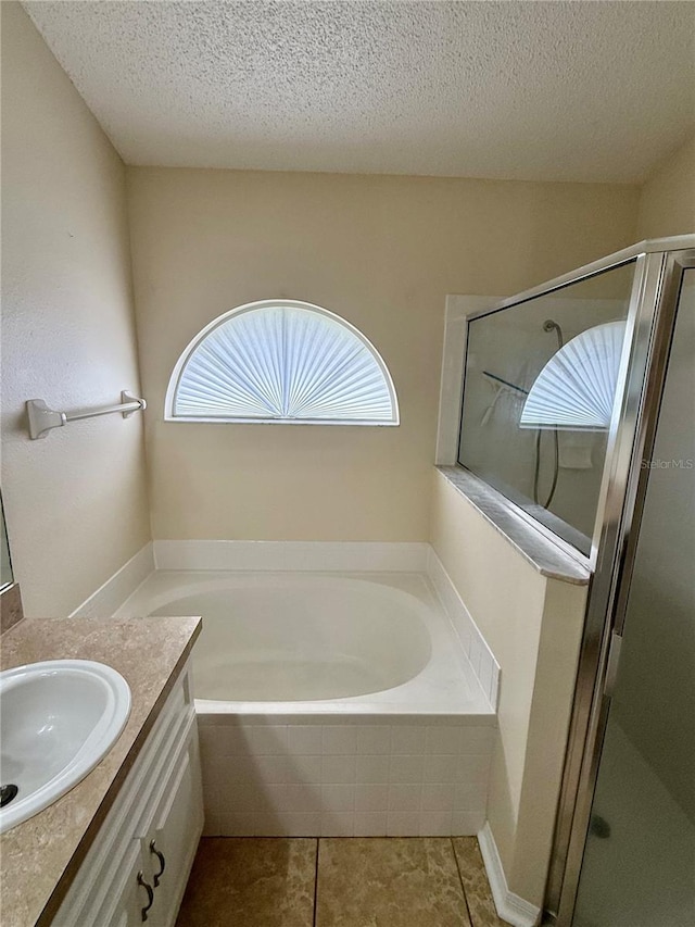 bathroom featuring a textured ceiling, vanity, tile patterned floors, and independent shower and bath