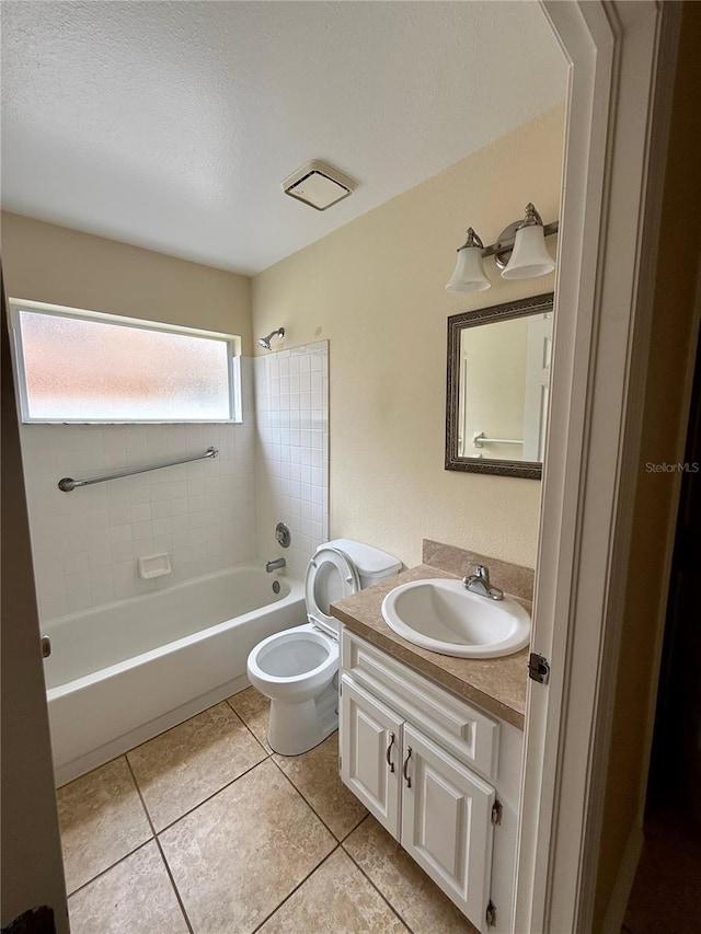 full bathroom featuring tiled shower / bath combo, tile patterned floors, a textured ceiling, toilet, and vanity