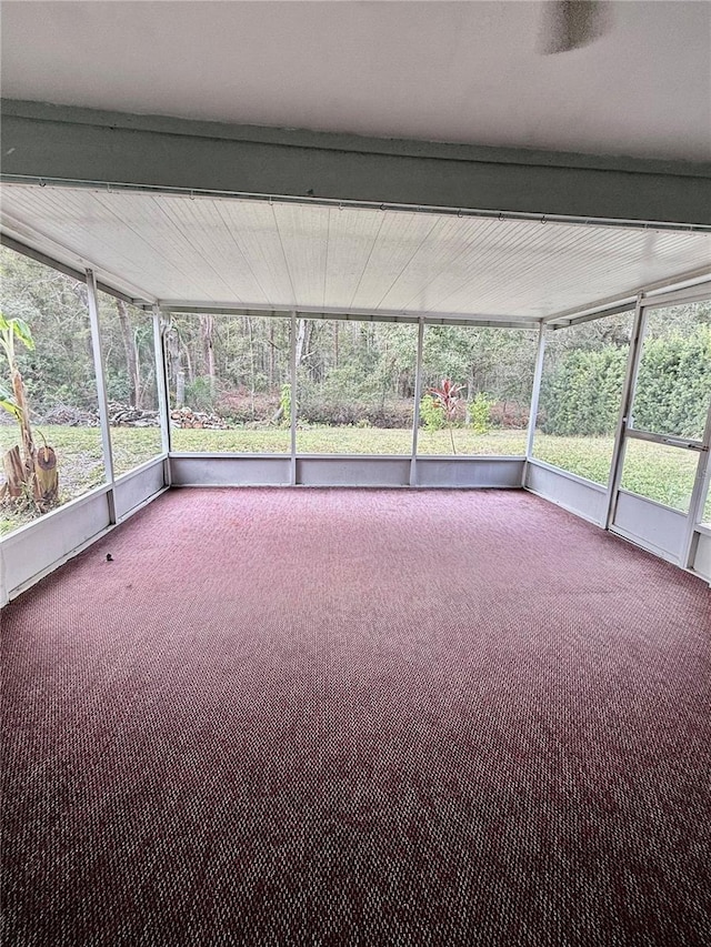 unfurnished sunroom with plenty of natural light and beam ceiling