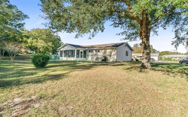 back of house with a lawn and a sunroom