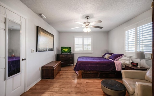 bedroom featuring ceiling fan, a textured ceiling, and light wood-type flooring