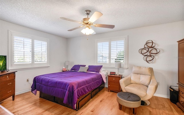 bedroom featuring ceiling fan, light hardwood / wood-style floors, and a textured ceiling