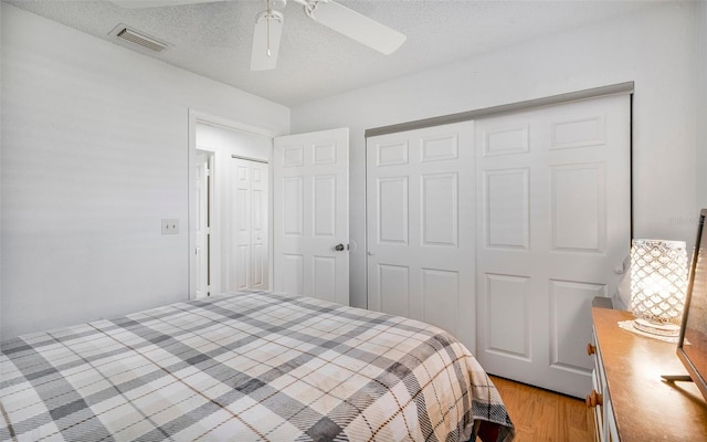 bedroom featuring a textured ceiling, light hardwood / wood-style flooring, and ceiling fan