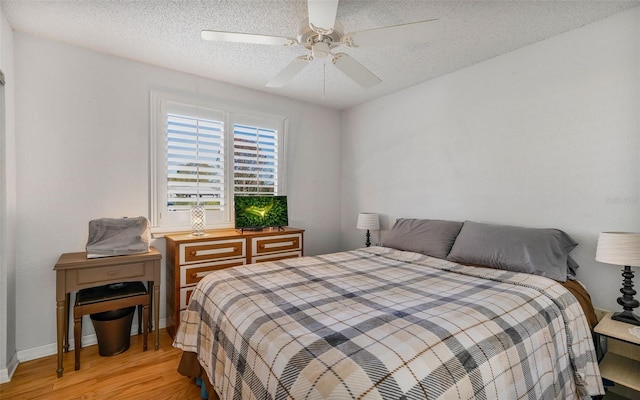 bedroom featuring a textured ceiling, light hardwood / wood-style floors, and ceiling fan