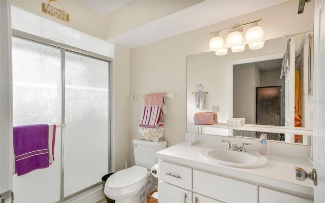 bathroom featuring vanity, toilet, and a shower with shower door