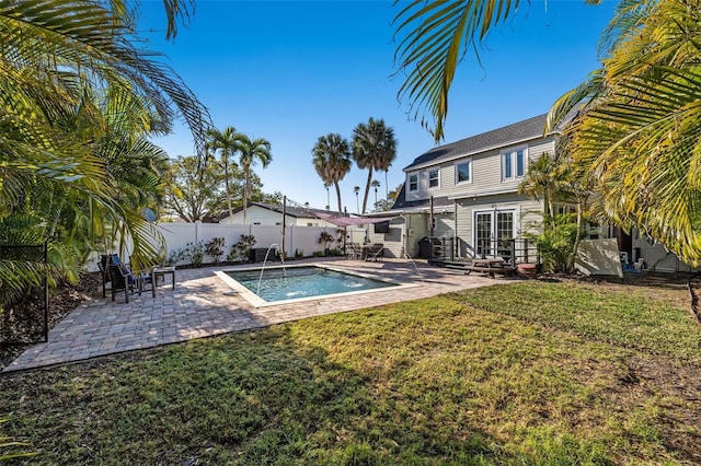 view of swimming pool with a lawn, french doors, and a patio