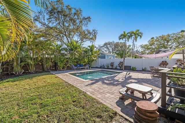 view of pool with pool water feature, a patio, and a lawn