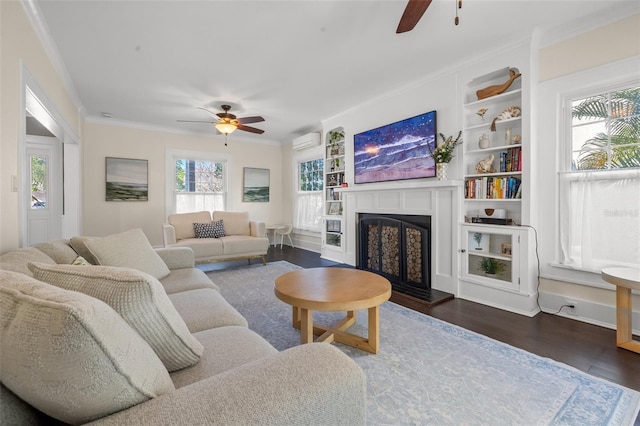 living room with a wall mounted air conditioner, ornamental molding, ceiling fan, and dark wood-type flooring