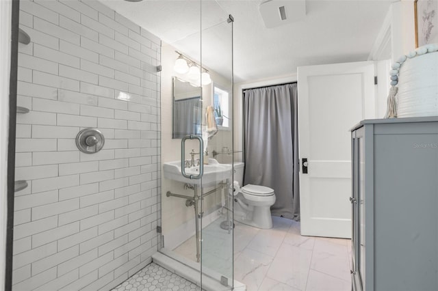 bathroom with a shower with shower door and toilet