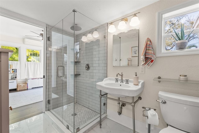 bathroom featuring toilet, ceiling fan, and a shower with shower door