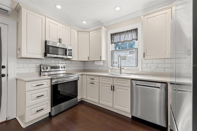 kitchen featuring white cabinetry, sink, a wall mounted air conditioner, and appliances with stainless steel finishes