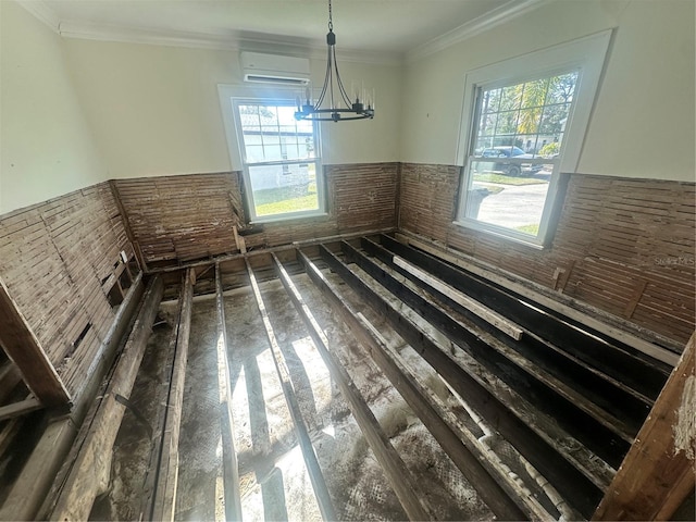 unfurnished dining area featuring a wall mounted air conditioner, a notable chandelier, and crown molding