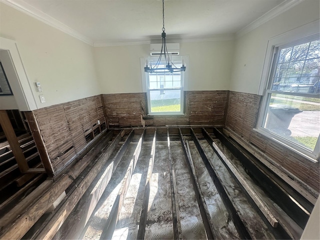 unfurnished dining area with a wall unit AC, crown molding, and a notable chandelier