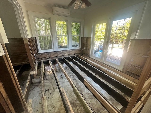 unfurnished sunroom with a wall mounted air conditioner, ceiling fan, and a healthy amount of sunlight