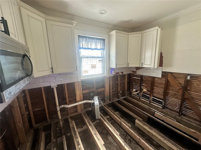 interior space featuring white cabinets and ornamental molding