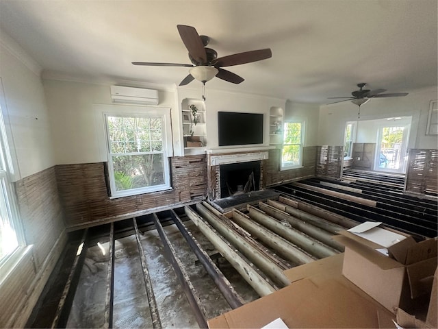 unfurnished living room with a wall unit AC, plenty of natural light, and ceiling fan