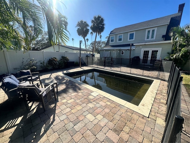 view of swimming pool featuring a patio and french doors