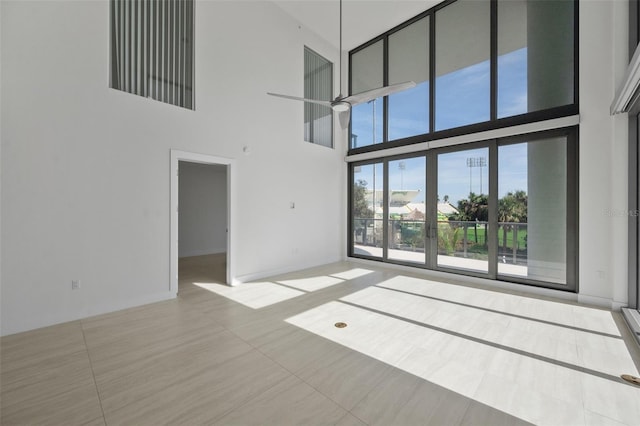 unfurnished living room featuring a high ceiling, tile patterned floors, and a healthy amount of sunlight