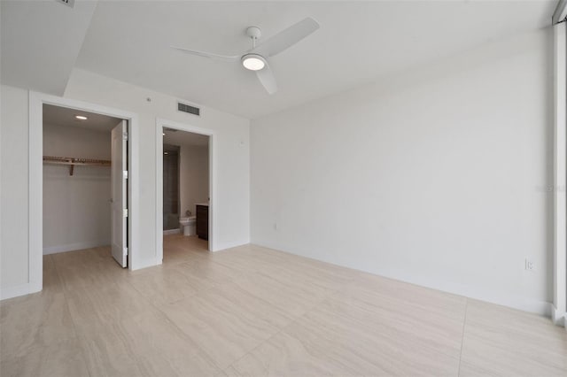 unfurnished bedroom with connected bathroom, ceiling fan, a closet, and a spacious closet