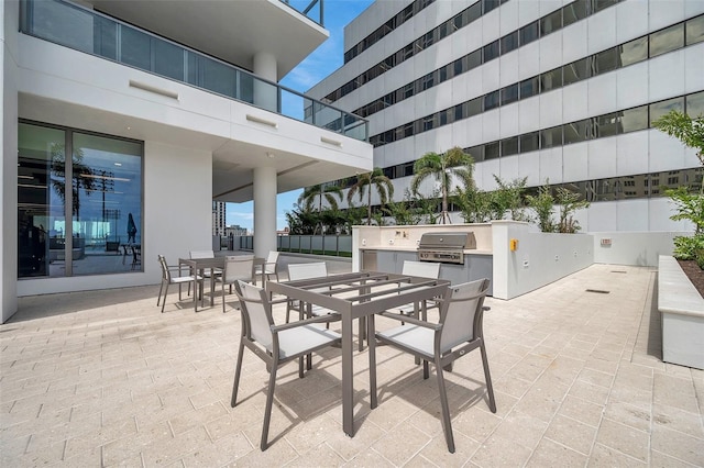 view of patio / terrace featuring area for grilling, a balcony, and an outdoor kitchen