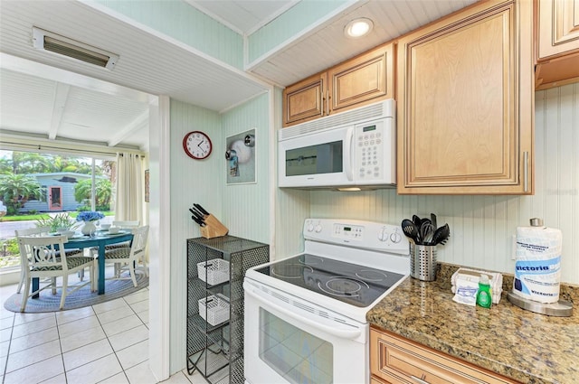 kitchen with light brown cabinetry, white appliances, light tile patterned floors, stone countertops, and beamed ceiling