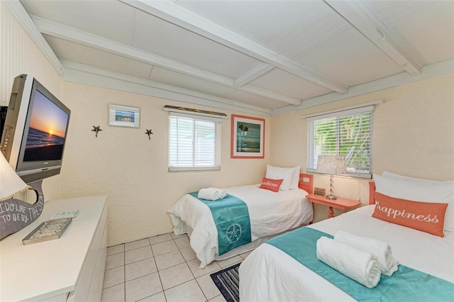 bedroom featuring beamed ceiling and light tile patterned floors