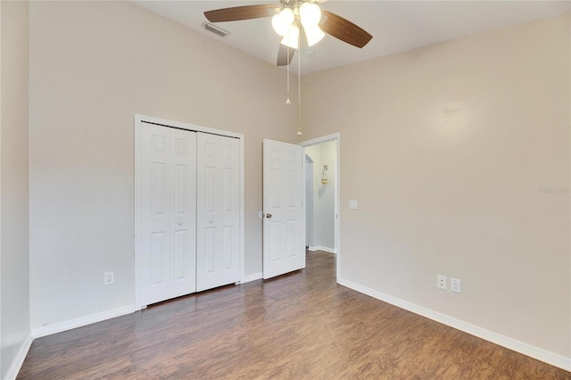 unfurnished bedroom with ceiling fan, dark hardwood / wood-style flooring, and a closet