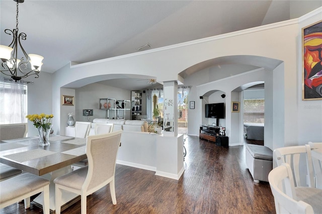 dining space with vaulted ceiling, plenty of natural light, ceiling fan with notable chandelier, and dark hardwood / wood-style flooring