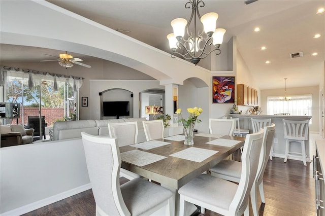 dining area featuring high vaulted ceiling, dark hardwood / wood-style floors, and ceiling fan with notable chandelier