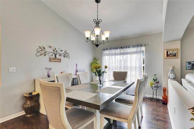 dining room featuring vaulted ceiling, dark hardwood / wood-style floors, and a chandelier