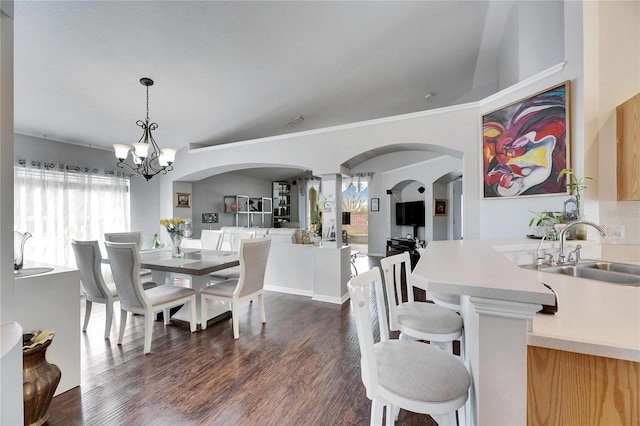 dining room with a healthy amount of sunlight, sink, a chandelier, and dark hardwood / wood-style flooring