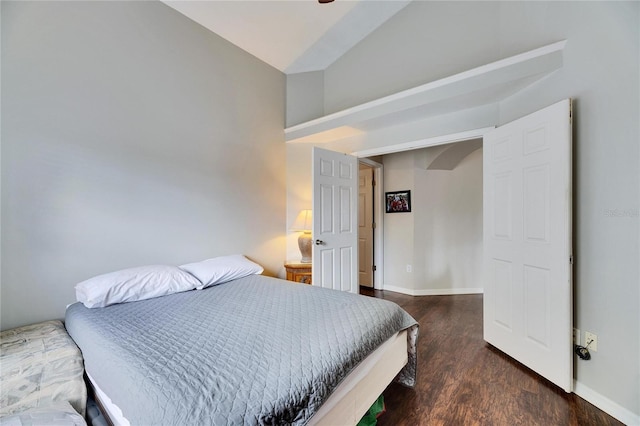 bedroom with vaulted ceiling and dark hardwood / wood-style flooring