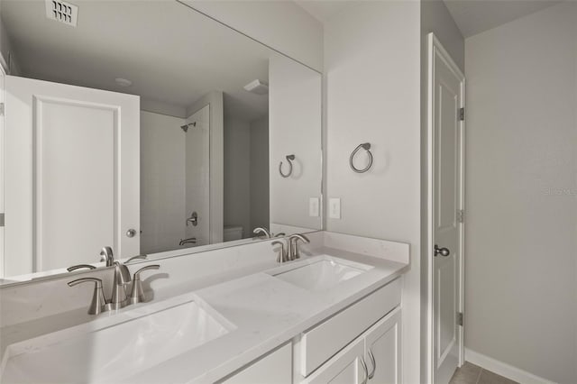 full bathroom with tiled shower / bath, tile patterned floors, toilet, and vanity