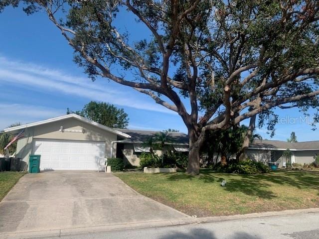 single story home featuring a garage and a front lawn