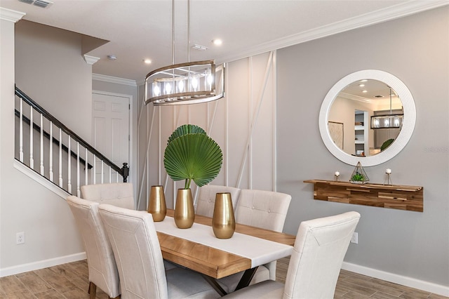 dining space featuring a chandelier, hardwood / wood-style flooring, and crown molding