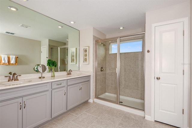 bathroom featuring tile patterned floors, vanity, and a shower with door